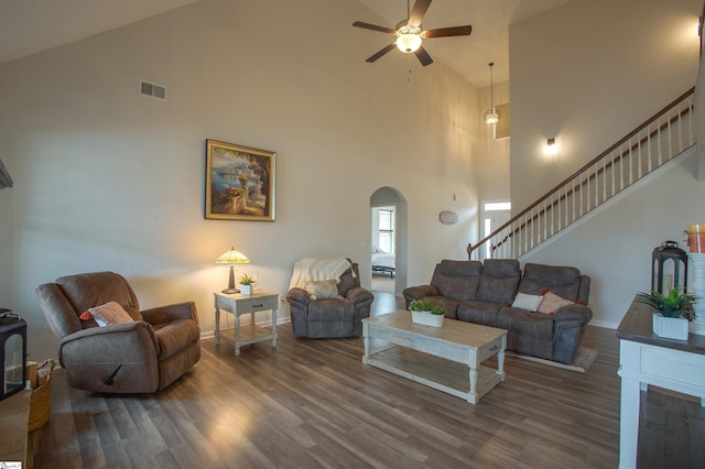 living room with wood finished floors, visible vents, arched walkways, and ceiling fan