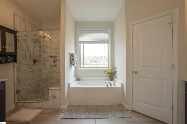 full bath with vanity, a shower stall, a garden tub, and baseboards