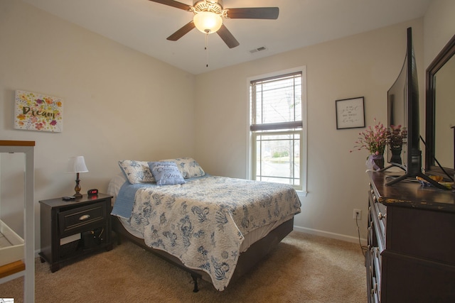 bedroom with visible vents, baseboards, light colored carpet, and a ceiling fan