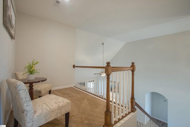 living area featuring baseboards, visible vents, light carpet, and lofted ceiling