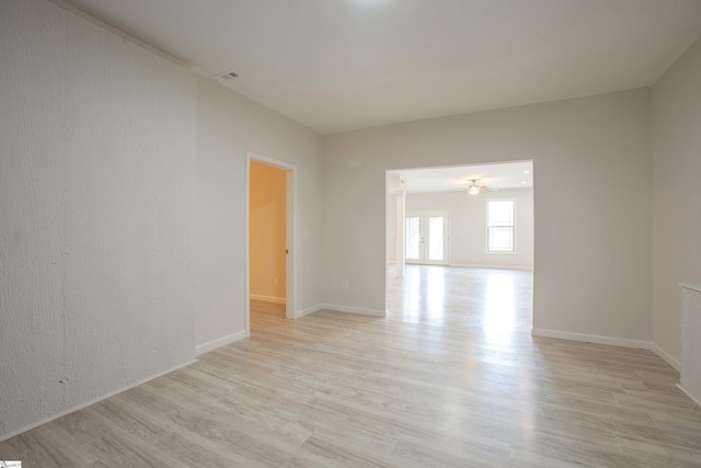 empty room with visible vents, baseboards, ceiling fan, and light wood finished floors