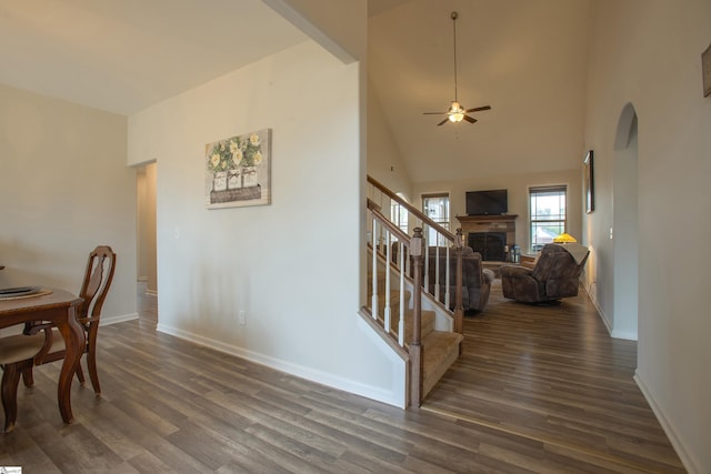 dining room with dark wood-type flooring, stairway, baseboards, and ceiling fan