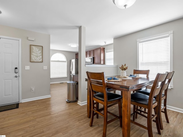 dining room featuring baseboards and light wood finished floors