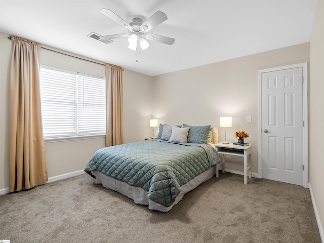 carpeted bedroom with visible vents, a ceiling fan, and baseboards