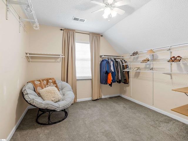 walk in closet featuring visible vents, a ceiling fan, carpet, and vaulted ceiling