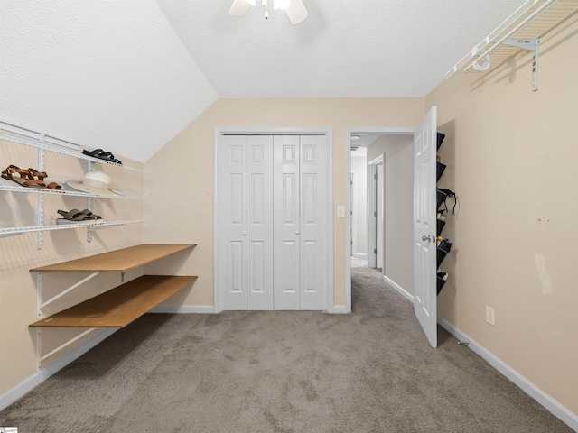 spacious closet featuring vaulted ceiling, carpet, and ceiling fan