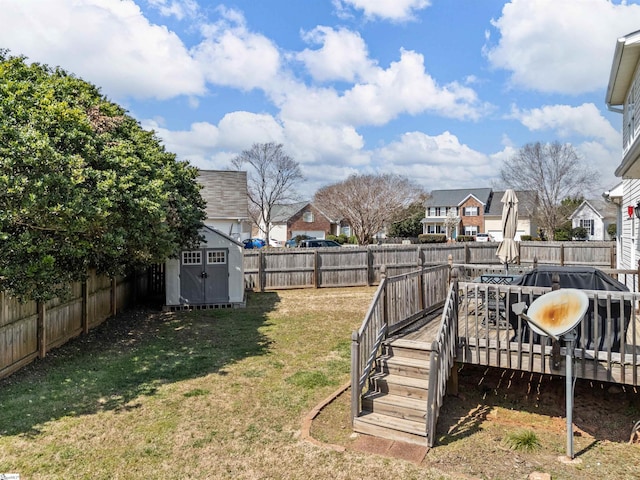 view of yard featuring an outbuilding, a residential view, a storage unit, and a fenced backyard