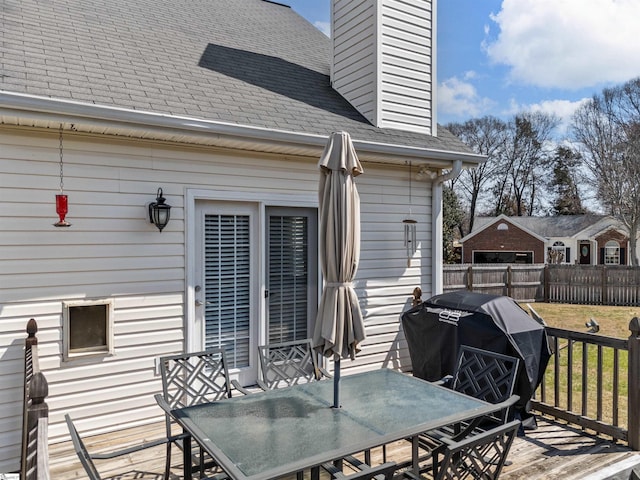 wooden terrace with a lawn, area for grilling, outdoor dining space, and fence