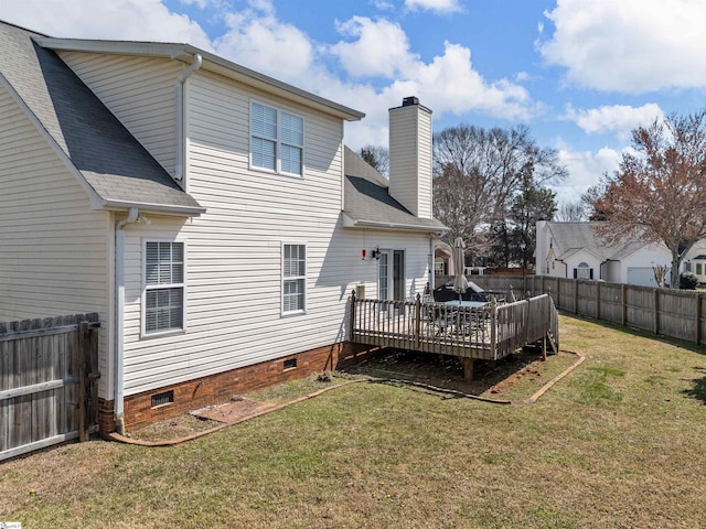 rear view of property featuring a wooden deck, a lawn, a chimney, a fenced backyard, and crawl space