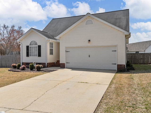 view of front of property with a front yard, concrete driveway, an attached garage, and fence