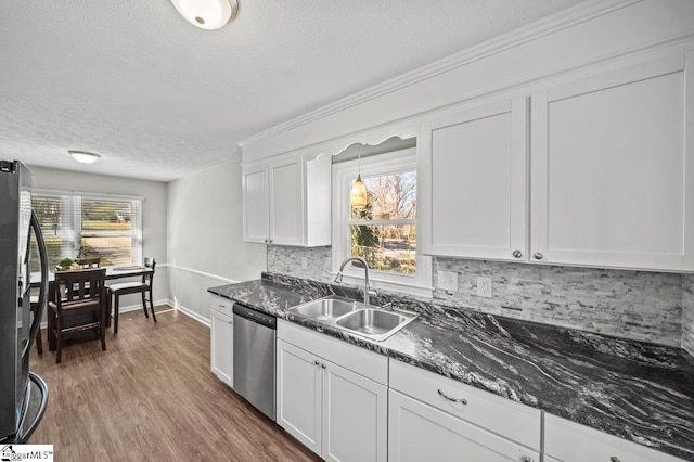 kitchen featuring wood finished floors, stainless steel appliances, a wealth of natural light, and a sink