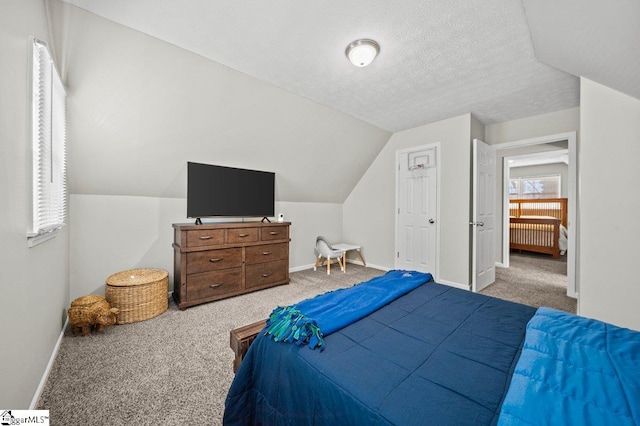 carpeted bedroom with vaulted ceiling, baseboards, and a textured ceiling