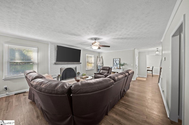 living room featuring a wealth of natural light, a brick fireplace, wood finished floors, and crown molding