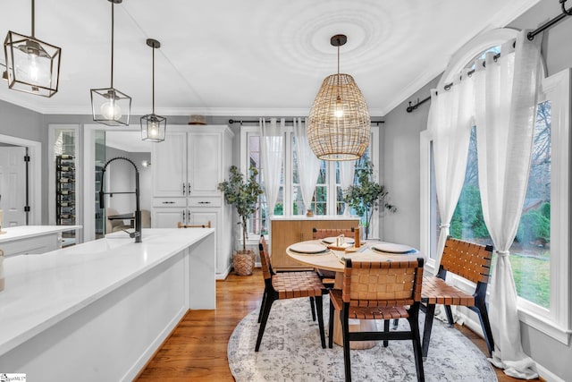 dining space featuring crown molding and light wood-type flooring