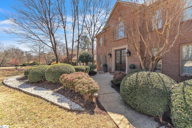exterior space with french doors and brick siding