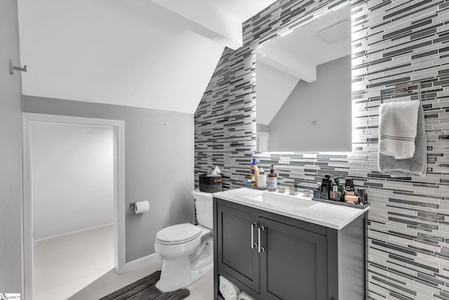 bathroom featuring tile patterned floors, toilet, lofted ceiling with beams, tasteful backsplash, and vanity