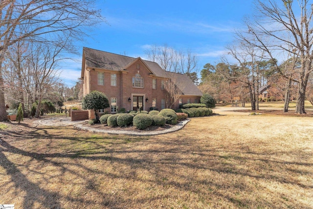view of home's exterior with brick siding and a yard
