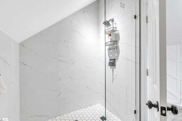 full bath with a shower stall and lofted ceiling