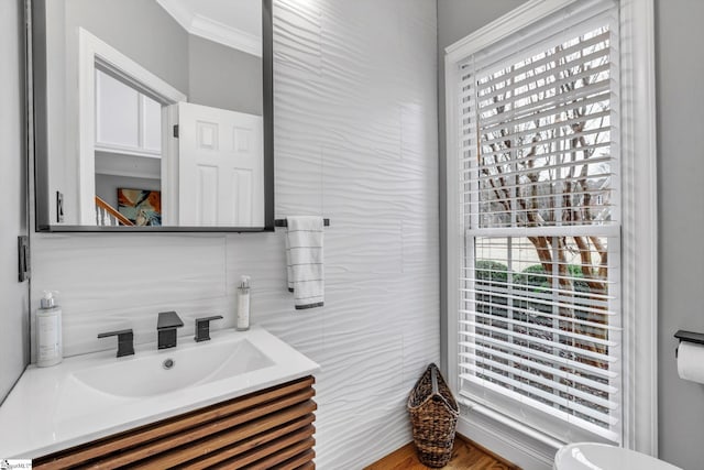 half bathroom with tasteful backsplash, vanity, crown molding, and tile walls