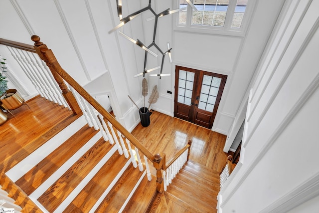 entryway featuring a high ceiling, french doors, stairs, and light wood-style floors
