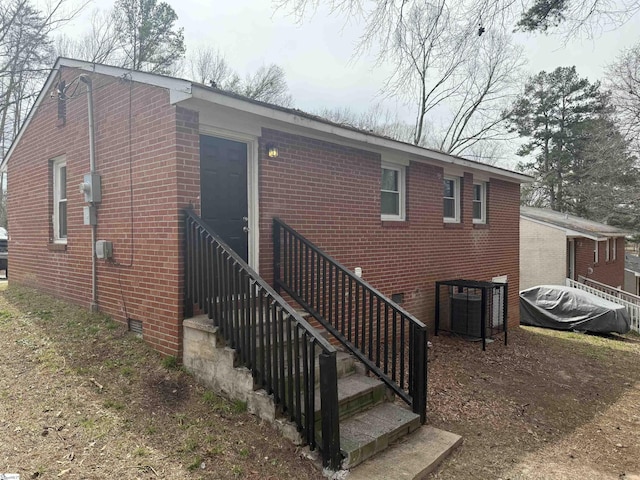 back of house with brick siding and crawl space