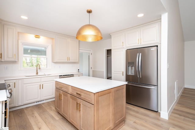 kitchen with a kitchen island, stainless steel fridge with ice dispenser, light wood-type flooring, and a sink
