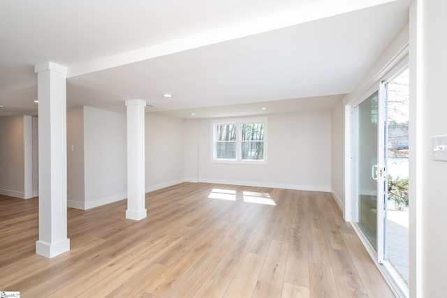 empty room featuring recessed lighting, baseboards, ornate columns, and light wood finished floors