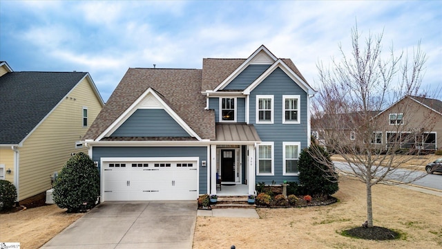 view of front of home featuring an attached garage, driveway, and a shingled roof