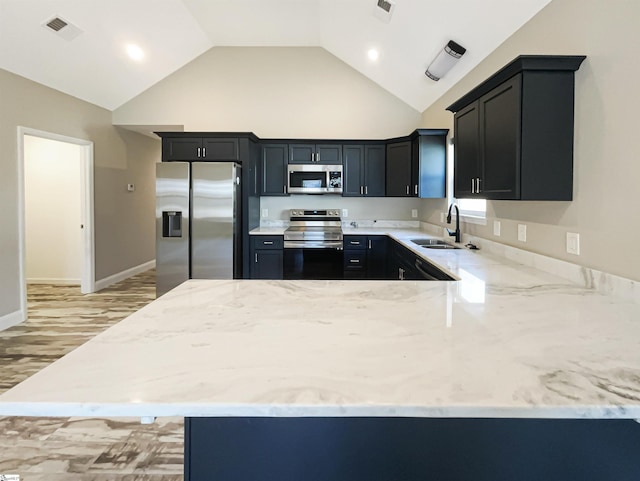 kitchen with light stone countertops, visible vents, a peninsula, a sink, and stainless steel appliances