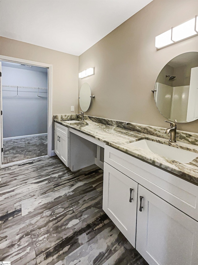 bathroom with a spacious closet and vanity