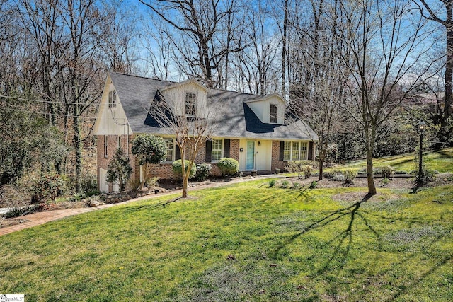 cape cod home with a front yard and brick siding