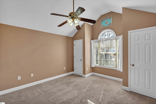 unfurnished bedroom featuring visible vents, baseboards, carpet floors, lofted ceiling, and ceiling fan