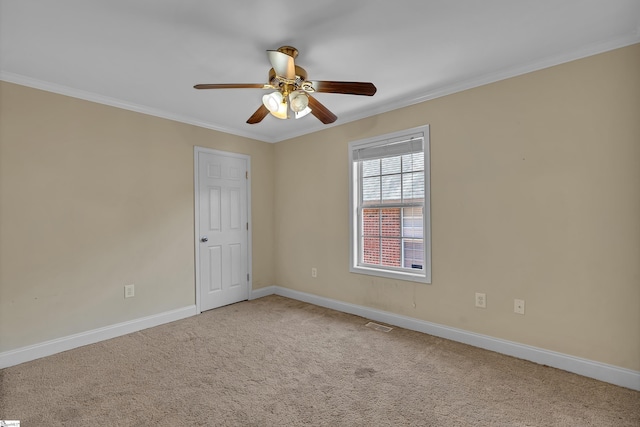 empty room featuring ceiling fan, carpet, baseboards, and ornamental molding