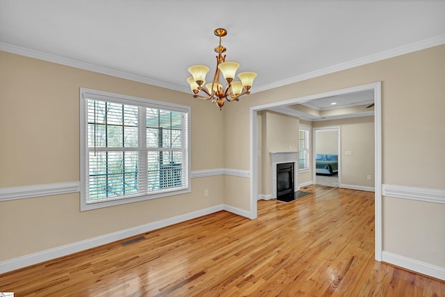 interior space featuring a chandelier, visible vents, light wood-style flooring, and ornamental molding
