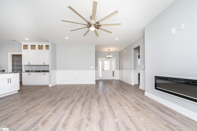 313 Barker Rd, Simpsonville, SC 29680 - unfurnished living room with recessed lighting, light wood-style floors, wainscoting, a decorative wall, and ceiling fan with notable chandelier