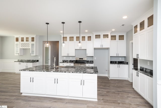 313 Barker Rd, Simpsonville, SC 29680 - kitchen featuring electric range, an island with sink, wood finished floors, and white cabinets