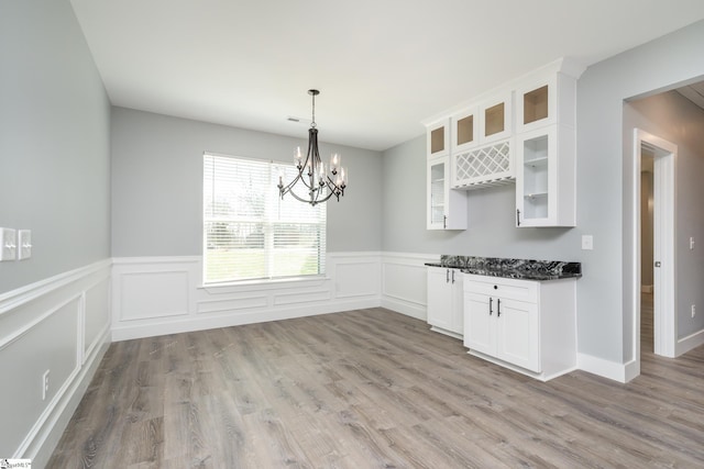313 Barker Rd, Simpsonville, SC 29680 - unfurnished dining area with a notable chandelier, wainscoting, and light wood-style floors
