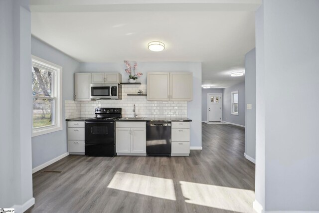 222 Poplar St, Gaffney, SC 29341 - kitchen featuring light wood-type flooring, decorative backsplash, dark countertops, and black appliances