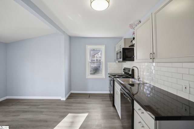 222 Poplar St, Gaffney, SC 29341 - kitchen featuring black appliances, dark countertops, wood finished floors, decorative backsplash, and baseboards