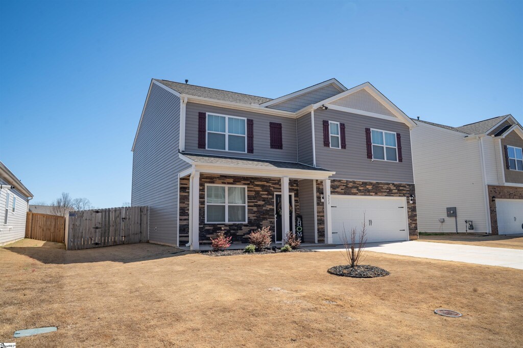 322 Callerton Dr, Piedmont, SC 29673 - view of front facade with stone siding, concrete driveway, an attached garage, and fence