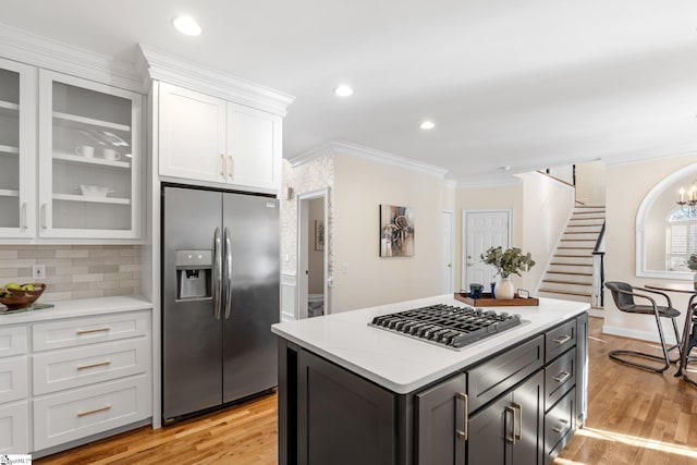 kitchen with white cabinetry, crown molding, light countertops, and appliances with stainless steel finishes