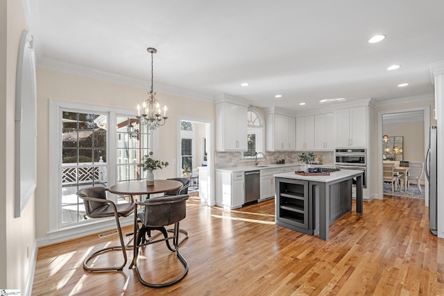 kitchen with light countertops, a notable chandelier, stainless steel appliances, and a sink