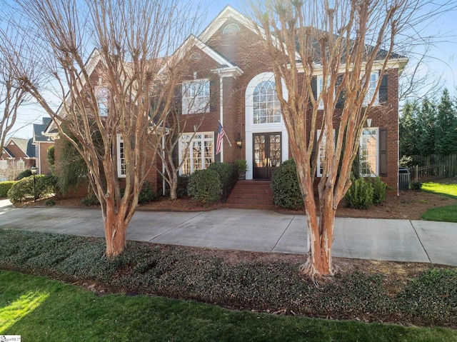 colonial inspired home with french doors and brick siding