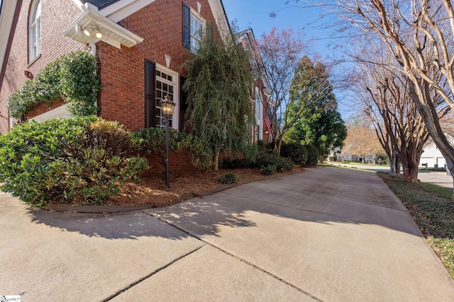 view of home's exterior with brick siding and driveway