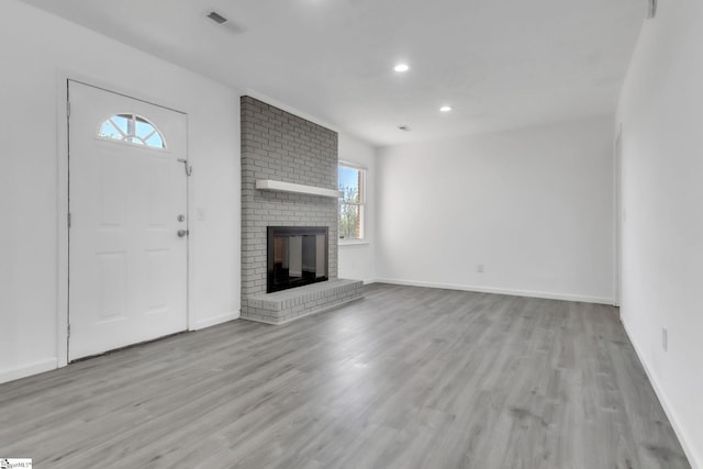 unfurnished living room featuring visible vents, a brick fireplace, baseboards, recessed lighting, and wood finished floors