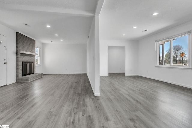 unfurnished living room featuring visible vents, recessed lighting, baseboards, and wood finished floors