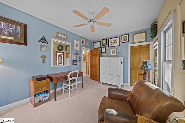 carpeted home office featuring baseboards and ceiling fan