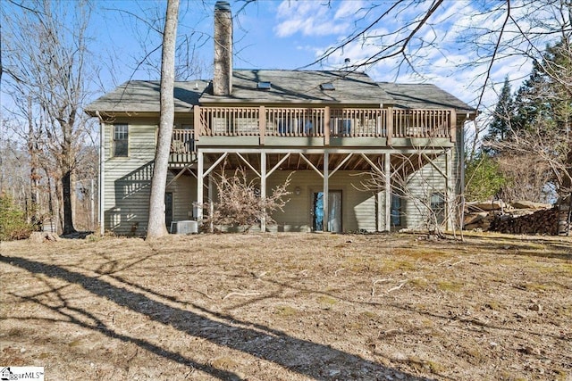 rear view of property with a deck, central AC, and a shingled roof