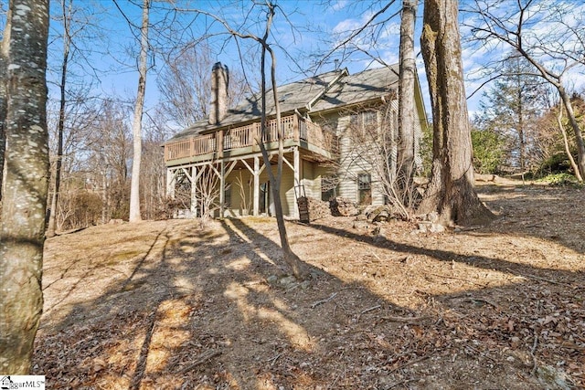 back of house featuring a deck and a chimney