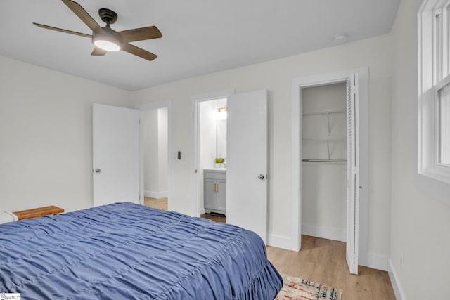 bedroom featuring a ceiling fan, light wood-style floors, a closet, and baseboards